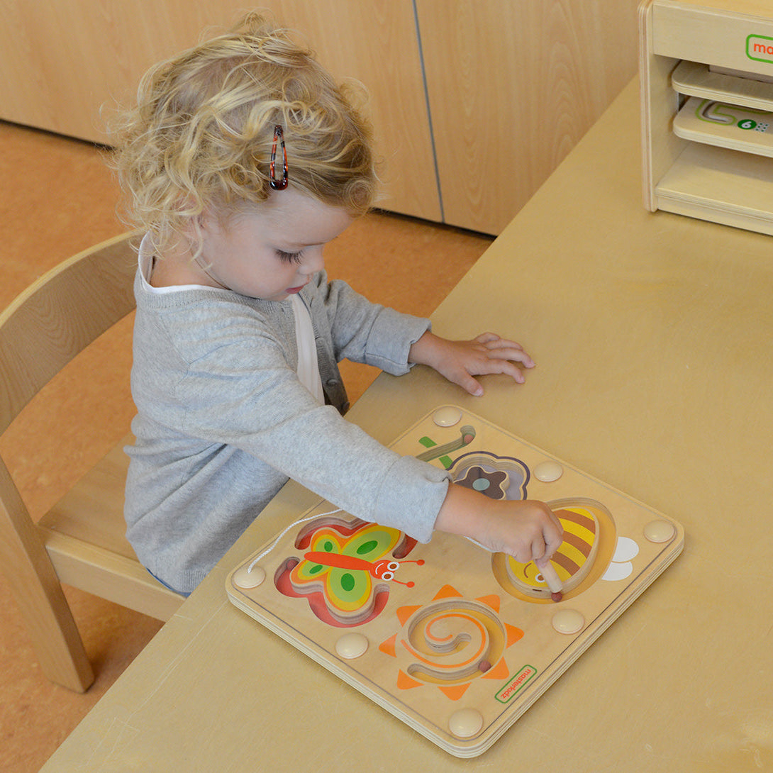 Magnetic pen guiding beads through enclosed maze channels.