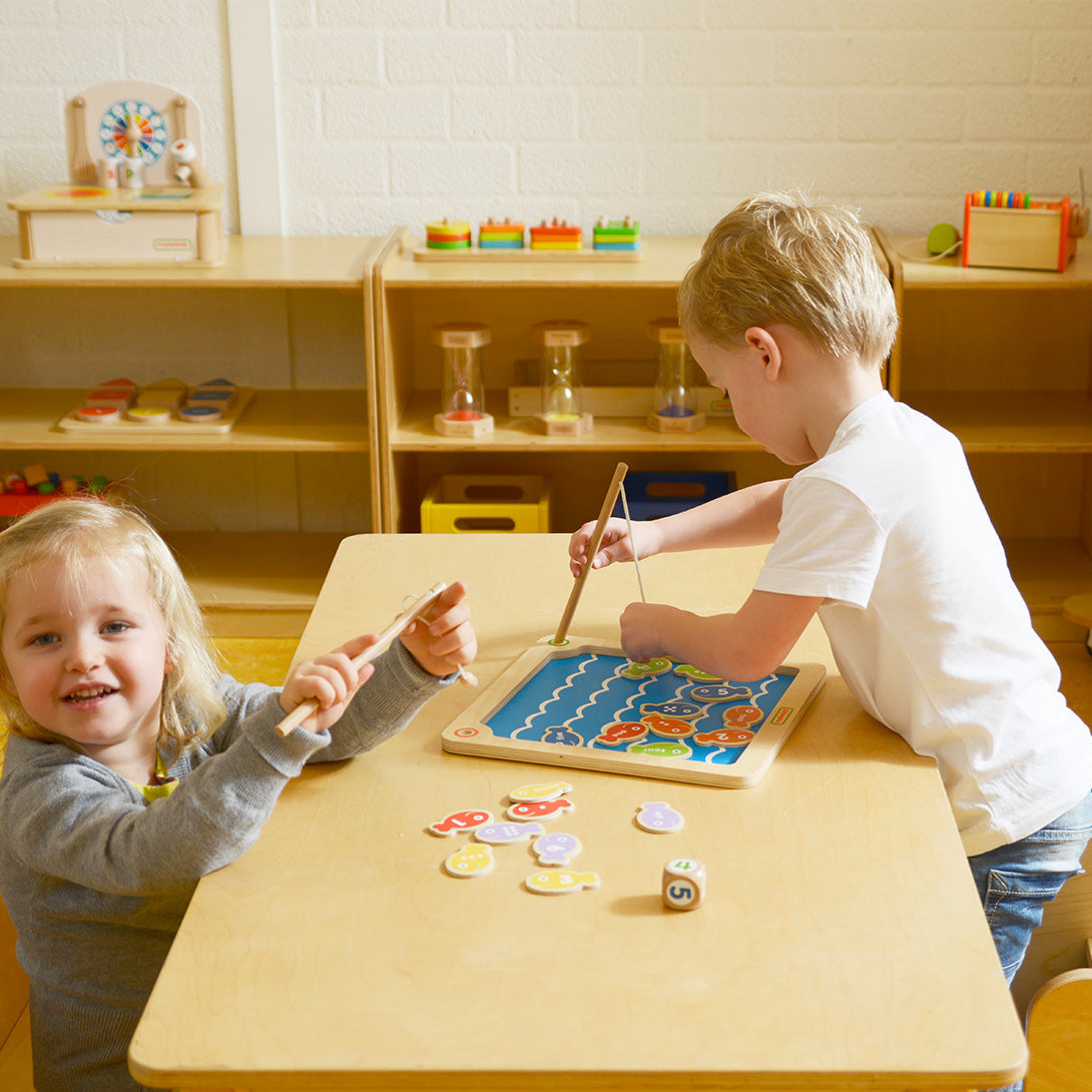 Kids playing with magnetic wooden sea creature fishing set