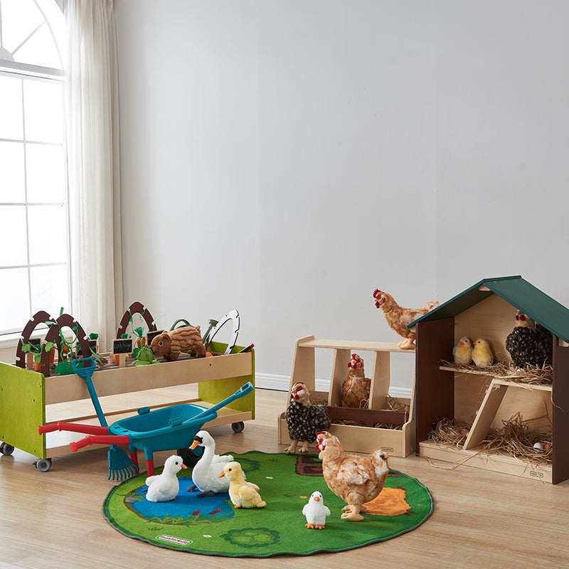 Child placing a play hen inside the stylish wooden hen house.