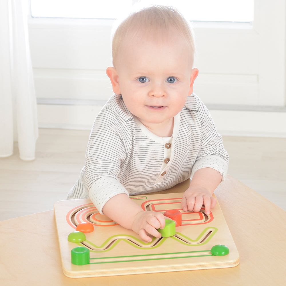 Montessori-inspired wooden sliding toy promoting hand-eye coordination.