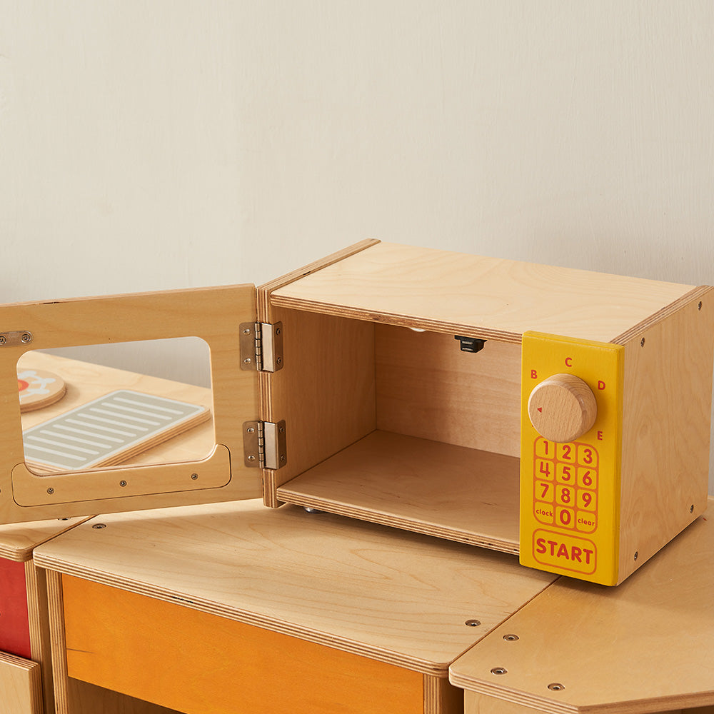Preschool role-play kitchen with pastel microwave unit.