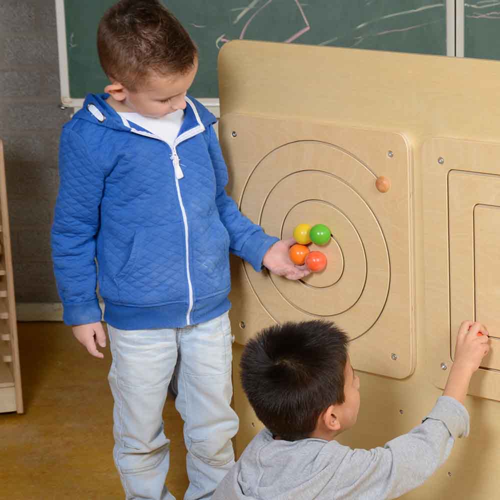 Children sliding pieces along spiral maze for hand-eye coordination