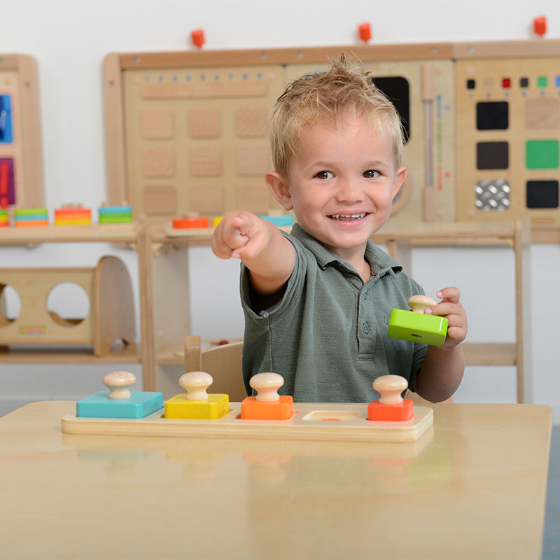 Children playing with color and size matching peg puzzle