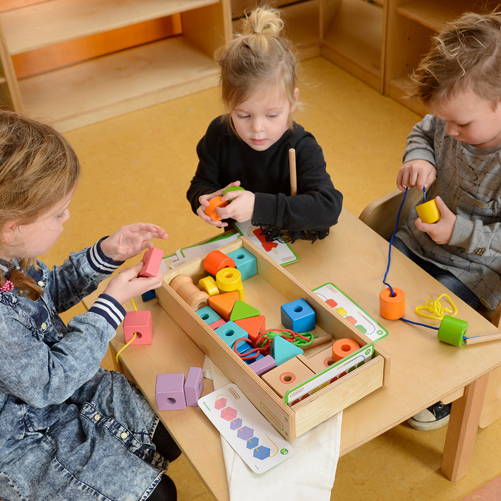 Children threading colourful beads for counting and matching