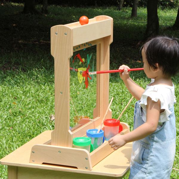 Children painting face to face on desktop painting window