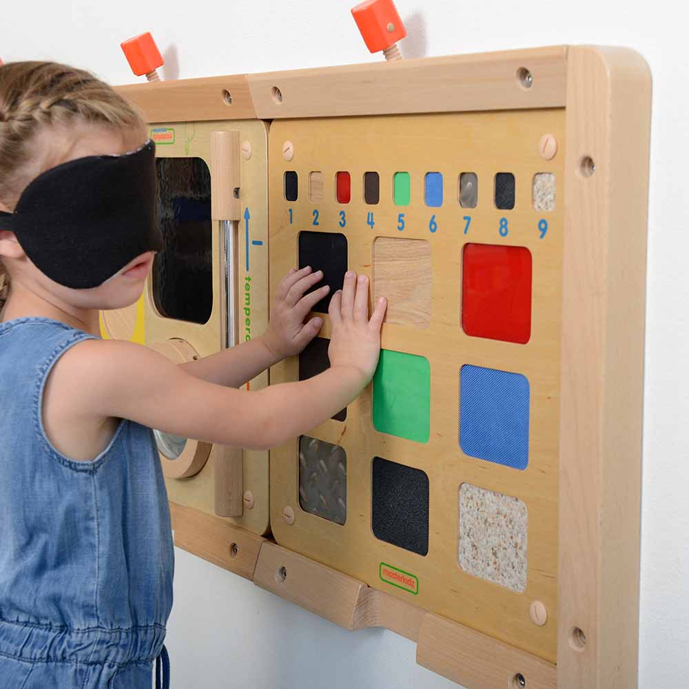 Children exploring tactile materials with sensory wall board