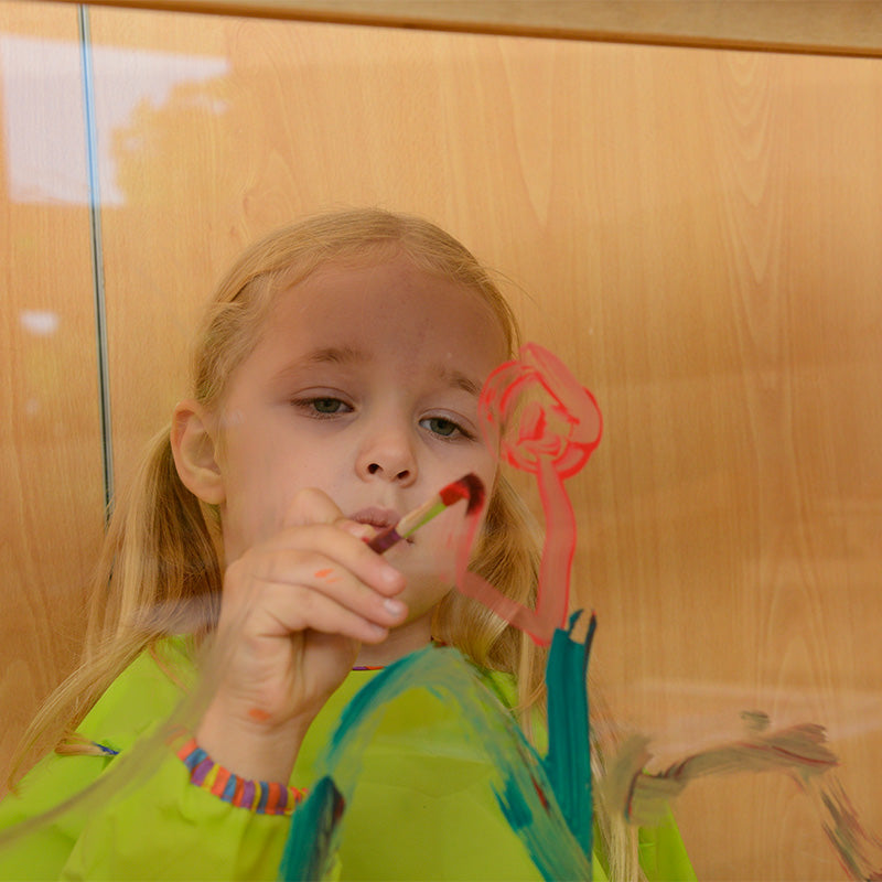 Children creating artwork on both sides of painting wall