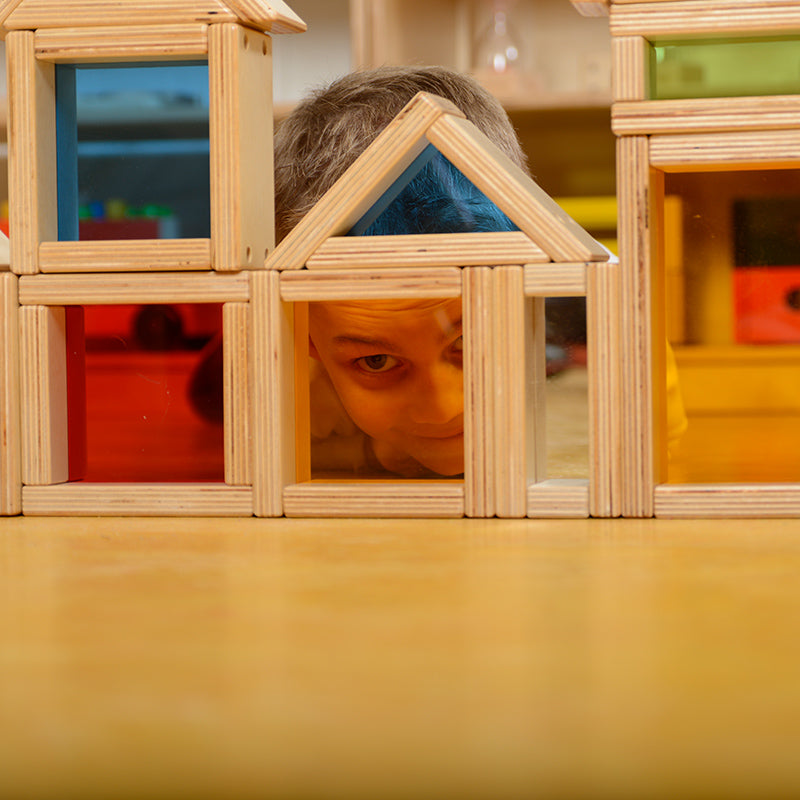 Mirror blocks reflecting surrounding objects on a classroom table.