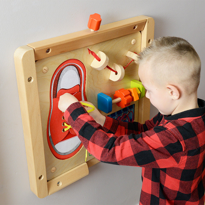 Kids practicing tying, rotating wooden nuts, and lacing strings on dexterity board