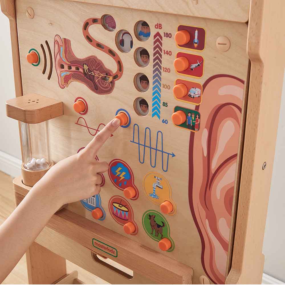 Children exploring sound vibration wall panel classroom