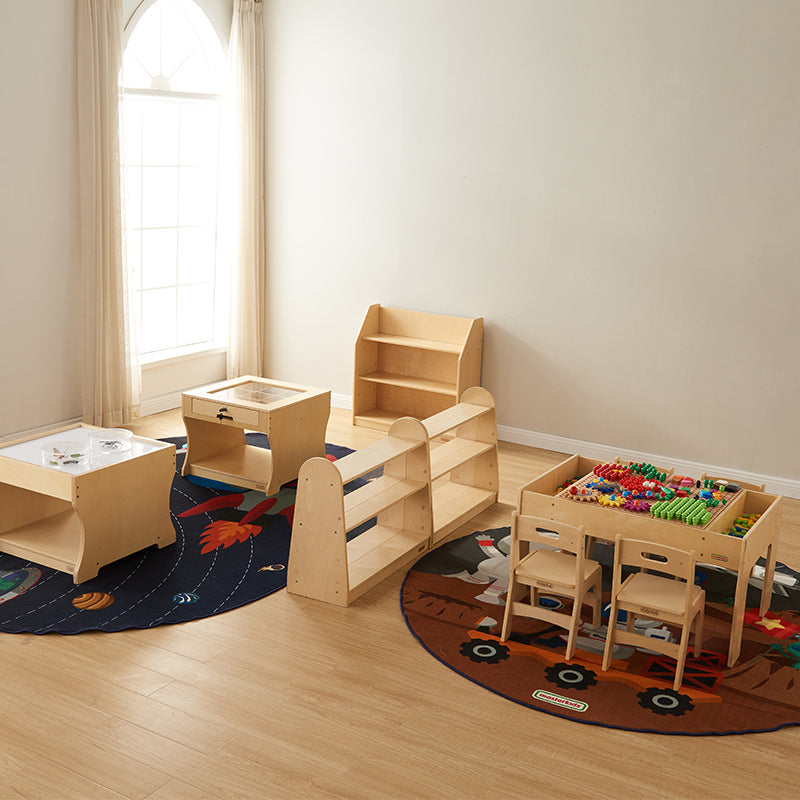 Children constructing structures using pegs, tiles, and bricks on the 930L STEM table.