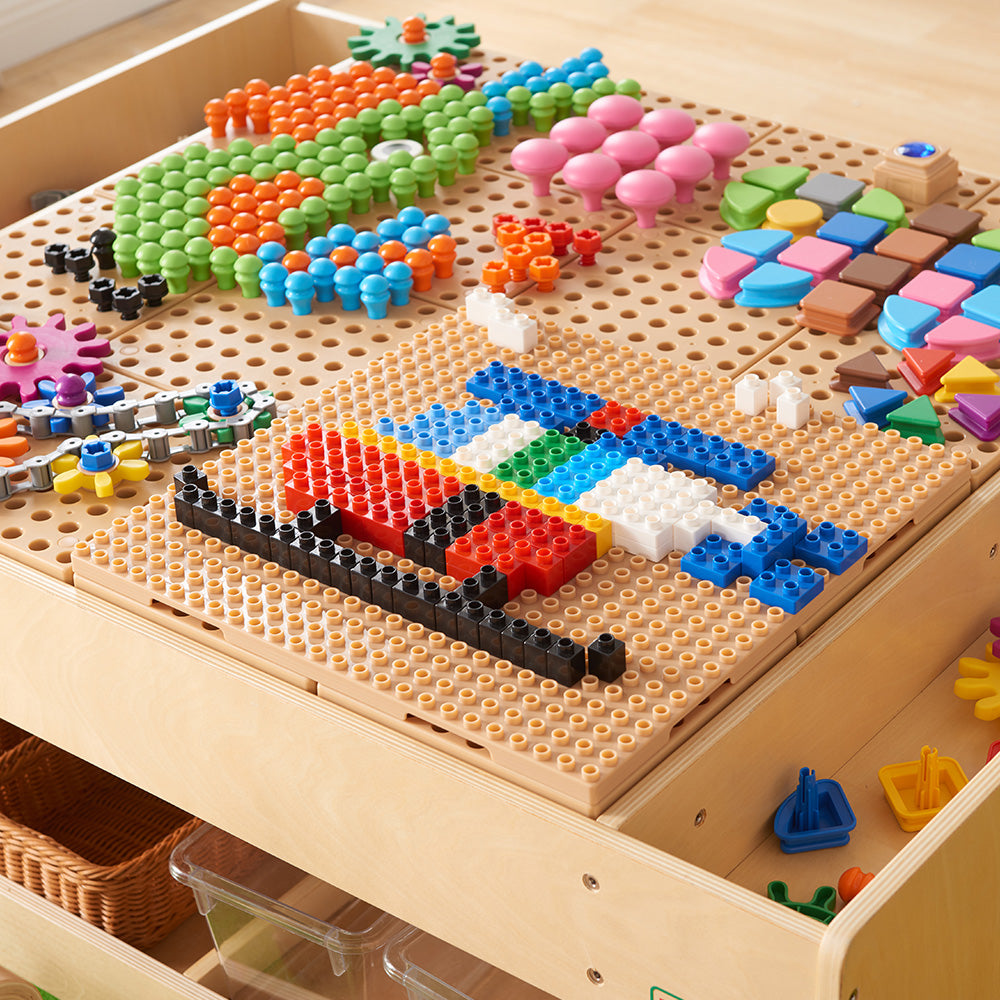 Children creating peg and shape designs on the STEM tile surface.