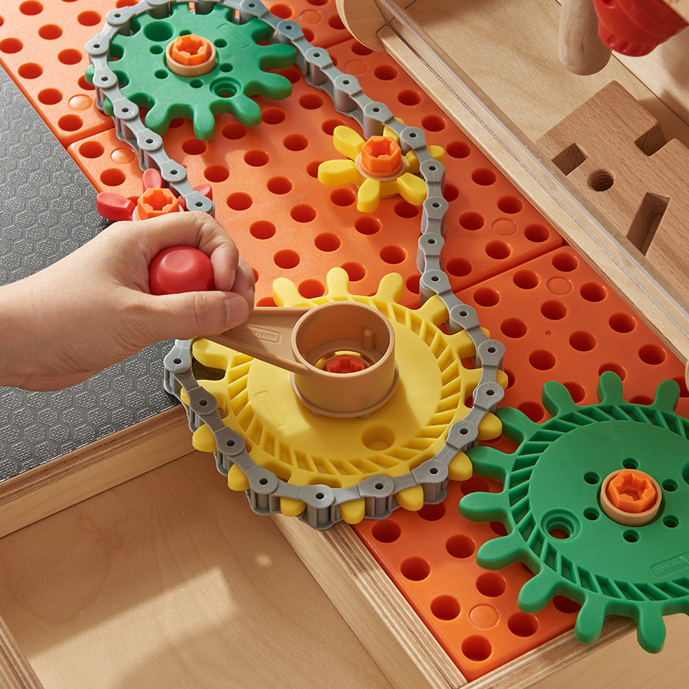 Workbench set up with gears, wheels, and pulleys for mechanical play.