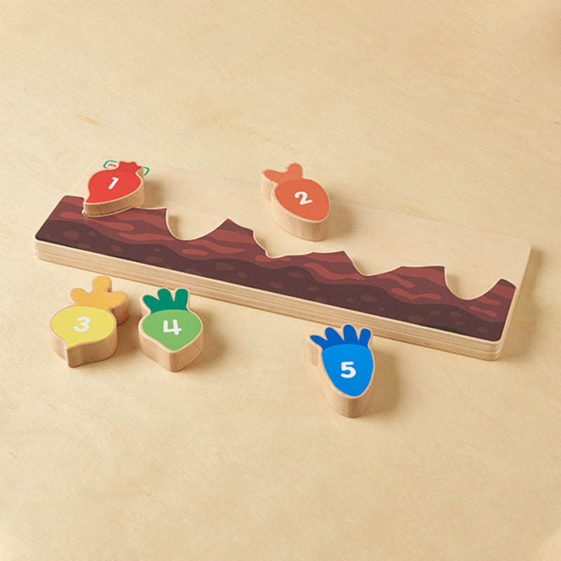 Child playing with 1-5 learning carrots, matching shapes and numbers.