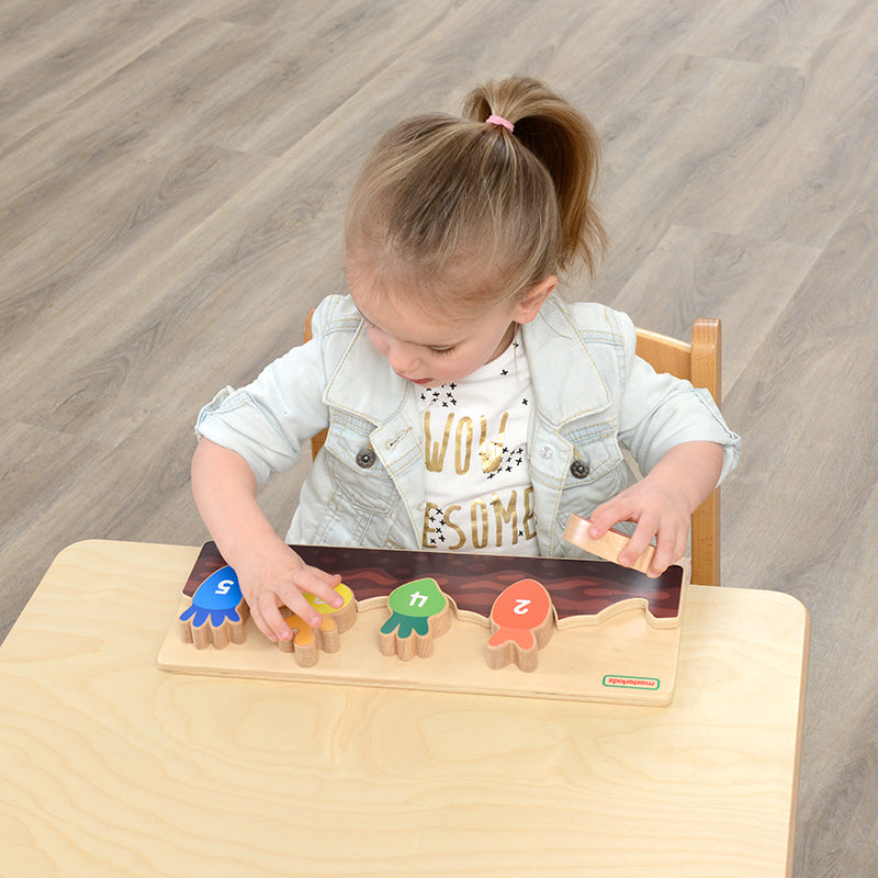 Preschool child practicing number recognition with Masterkidz carrots.