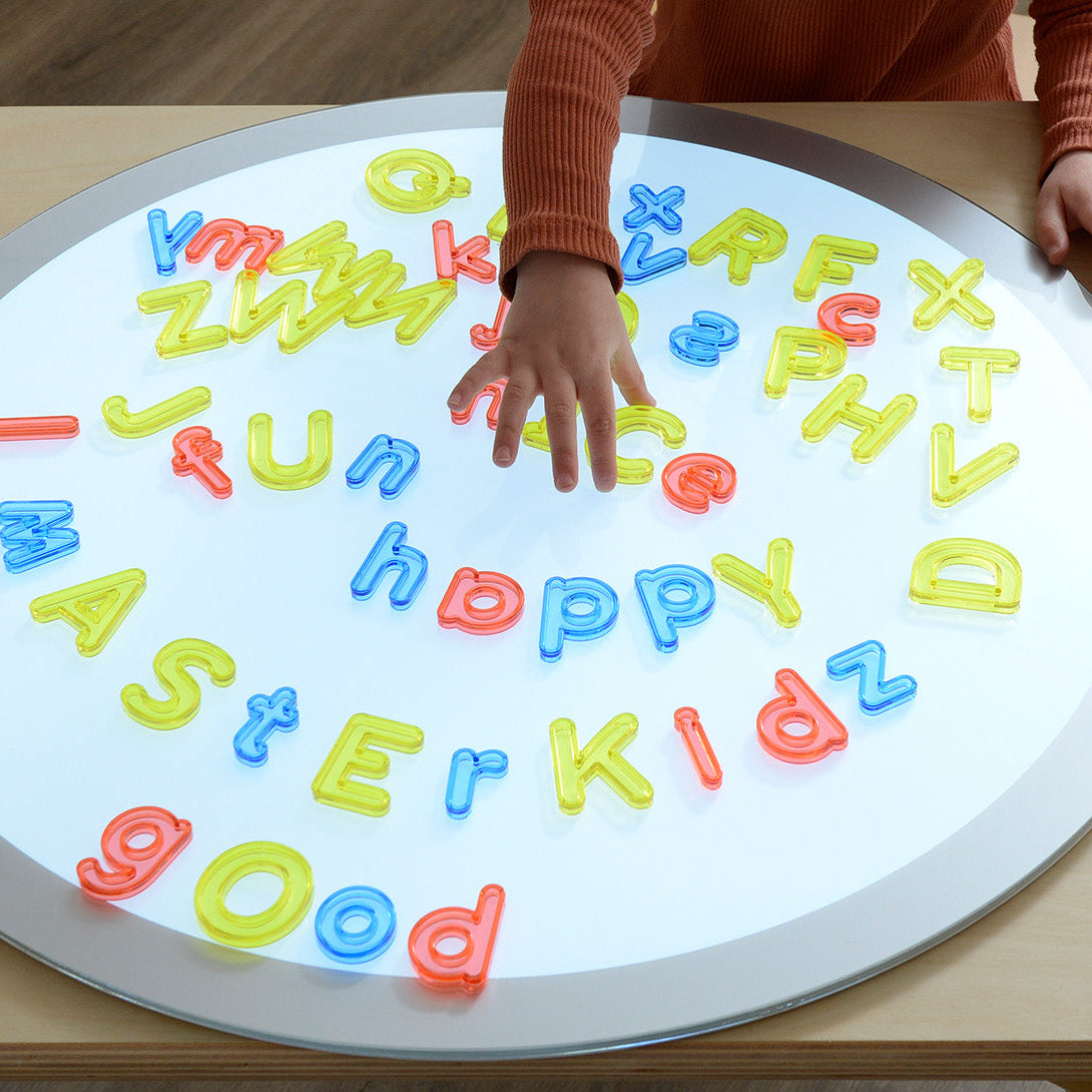 Children arranging translucent letters on a tabletop