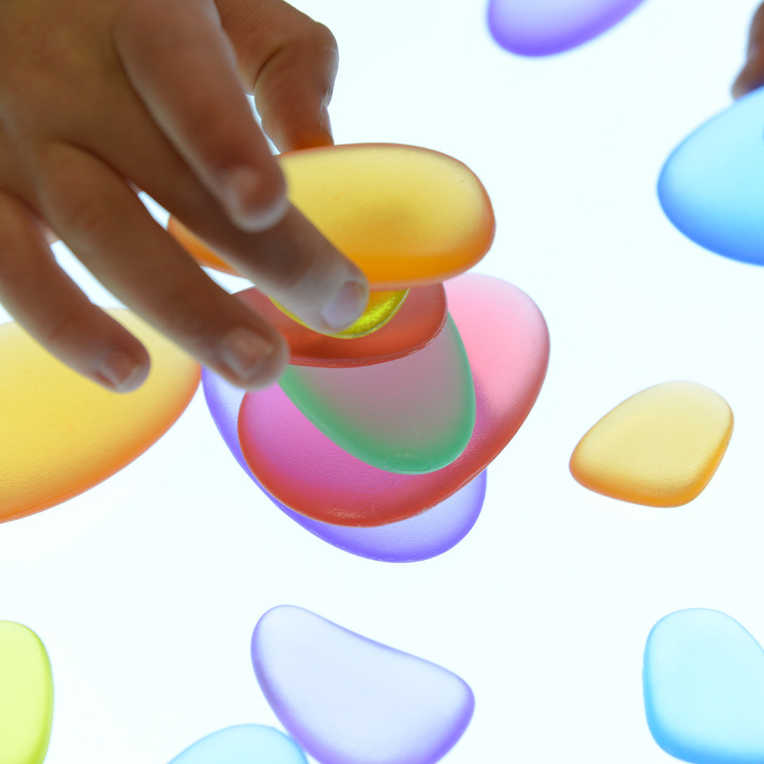 Children arranging translucent cobbles for colour mixing