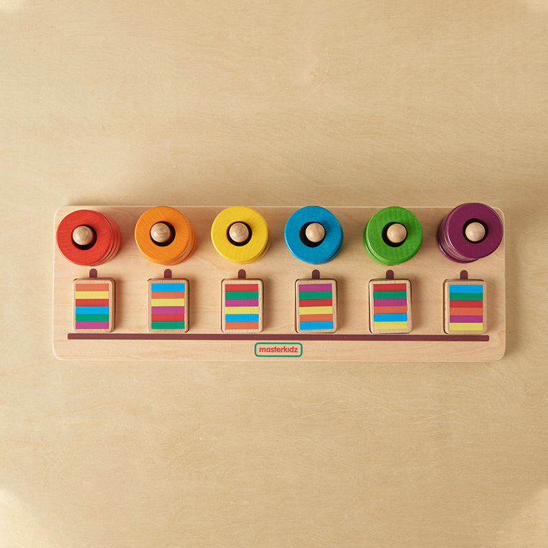 Toddler playing with Masterkidz ring stackers to practice logical thinking and fine motor skills.