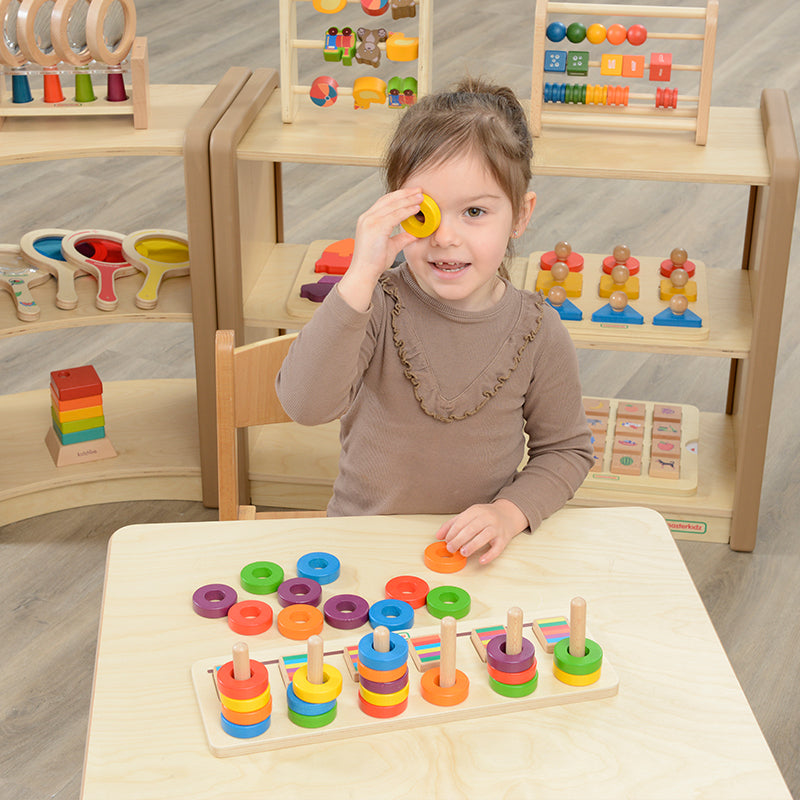 Child stacking rings in the correct sequence for spatial awareness development.