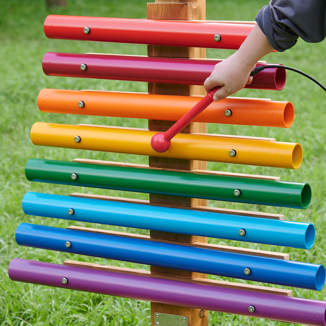 Side view showing sturdy frame and colourful chimes in use.