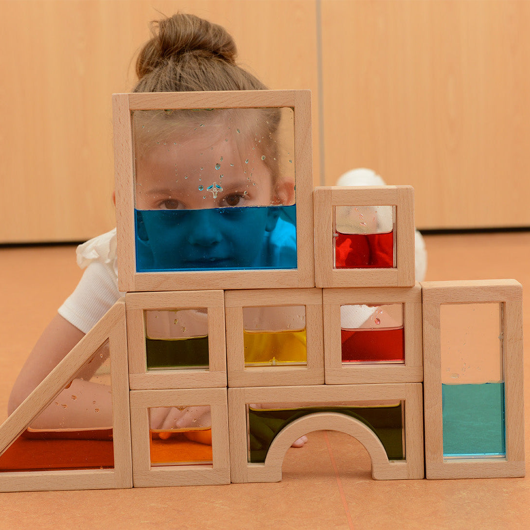 Full 18-piece Masterkidz Wooden Sensory Liquid Block set arranged by shape and colour.