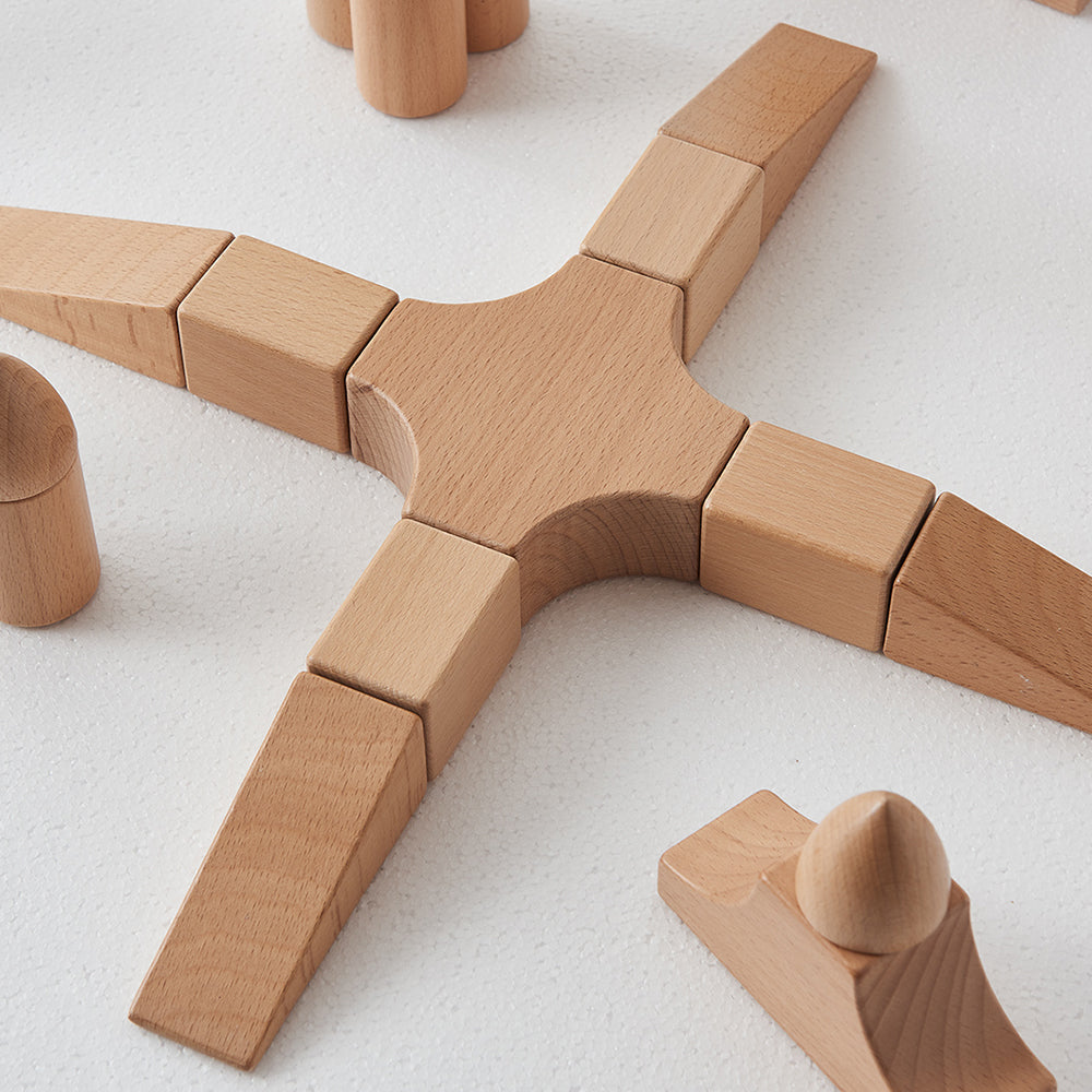 Open-ended small world play setup with knights and figures next to wooden castle structures.