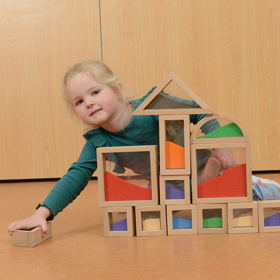 Child exploring tactile and auditory sensations by shaking a block.