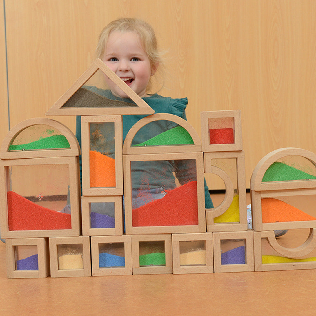 Teacher guiding children to sort blocks by colour and shape.