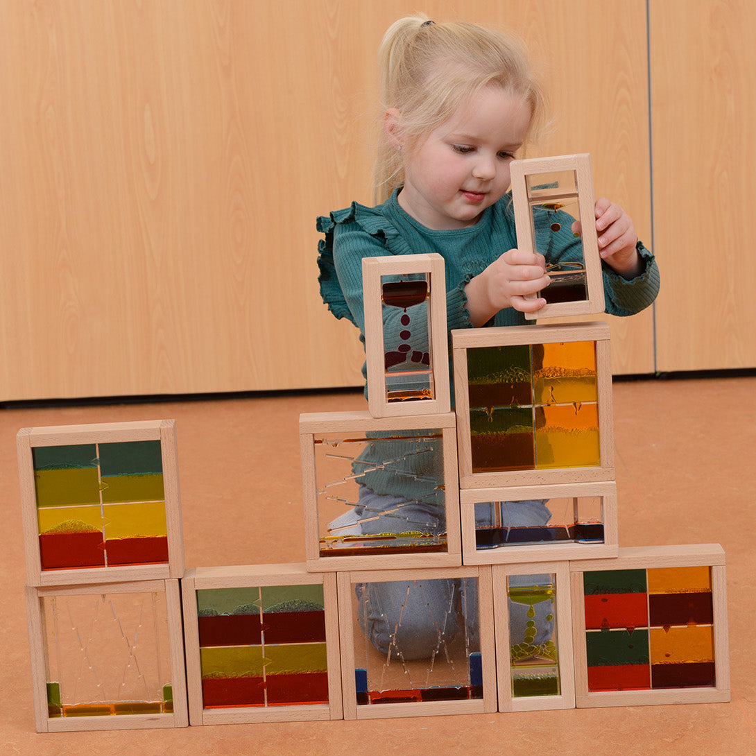 Children observing the blocks placed on a light panel for enhanced colour effects.