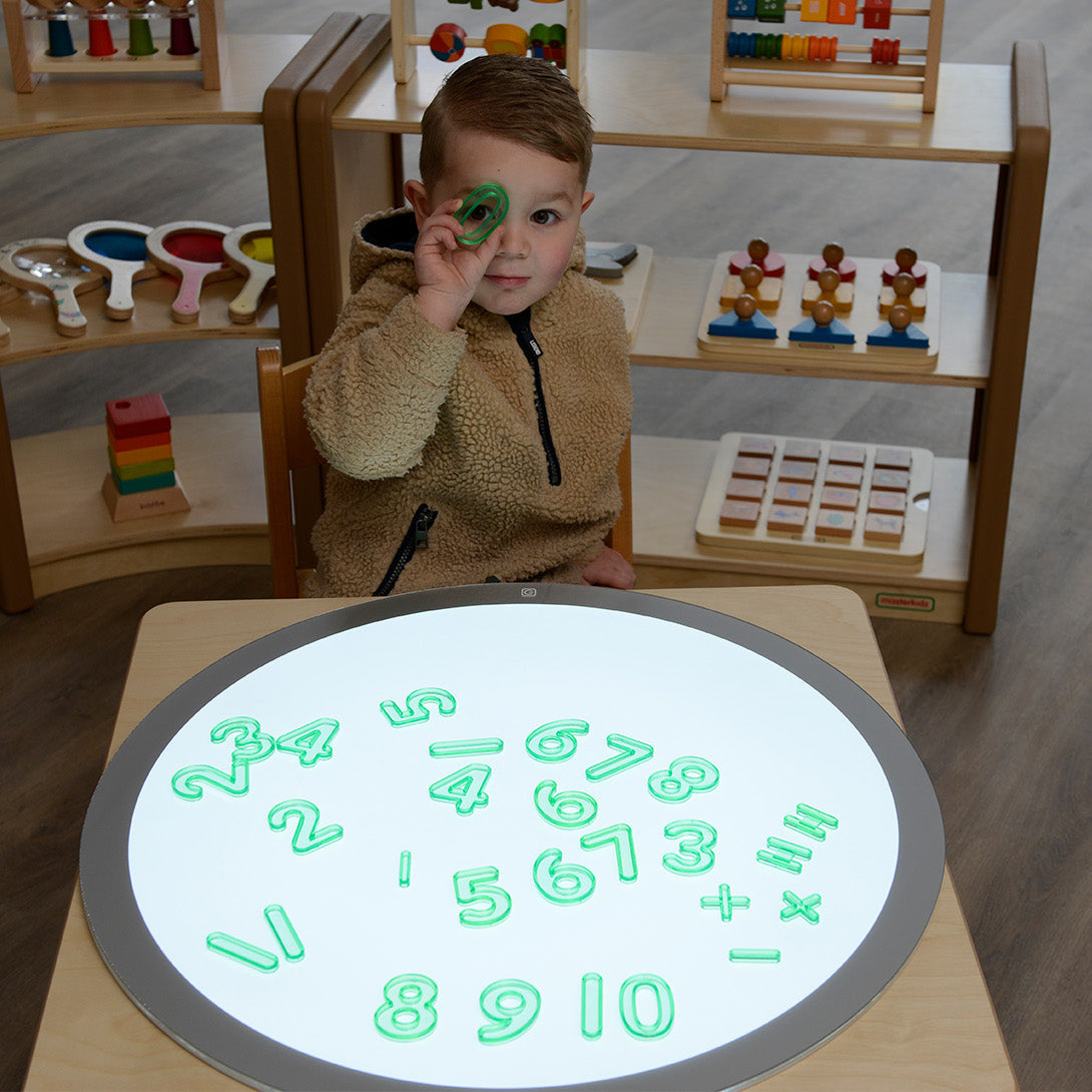 Children arranging numbers 1–10 in sequence during a classroom maths activity.