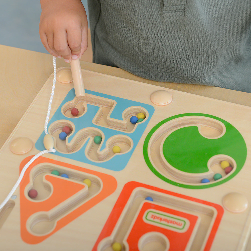 Preschool child using magnetic wand maze learning toy