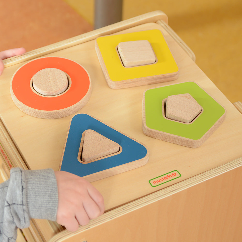 Toddler using the magnifying glass on the Masterkidz sensory board for STEM exploration.