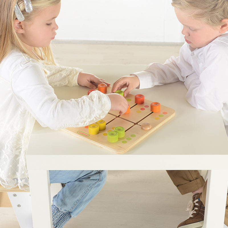 Toddler practicing fine motor skills using wooden colour matching toy.