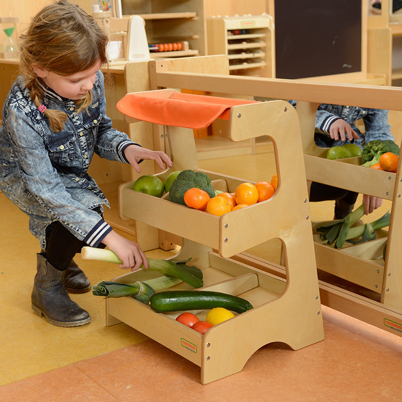 Kids pretending to shop at wooden market stand