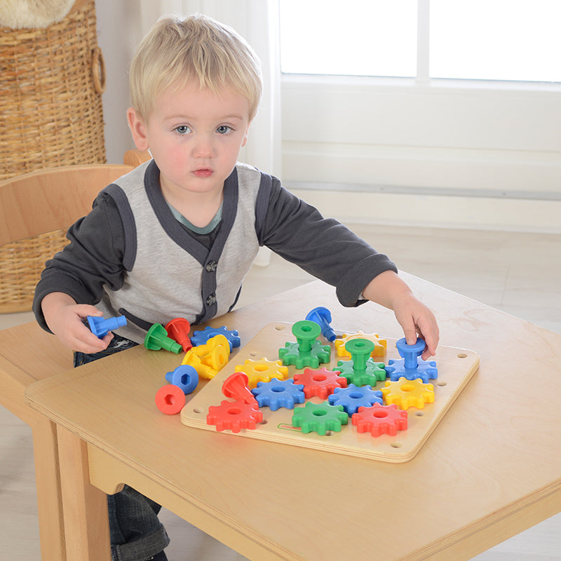 Child assembling gears to create a functional gear mechanism.