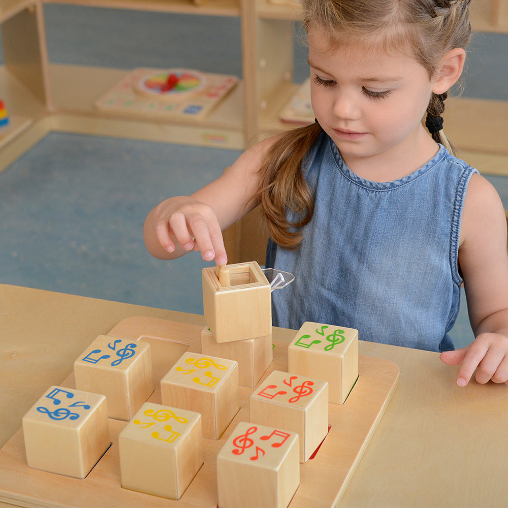 Empty wooden cube designed for inserting objects to create custom sounds.