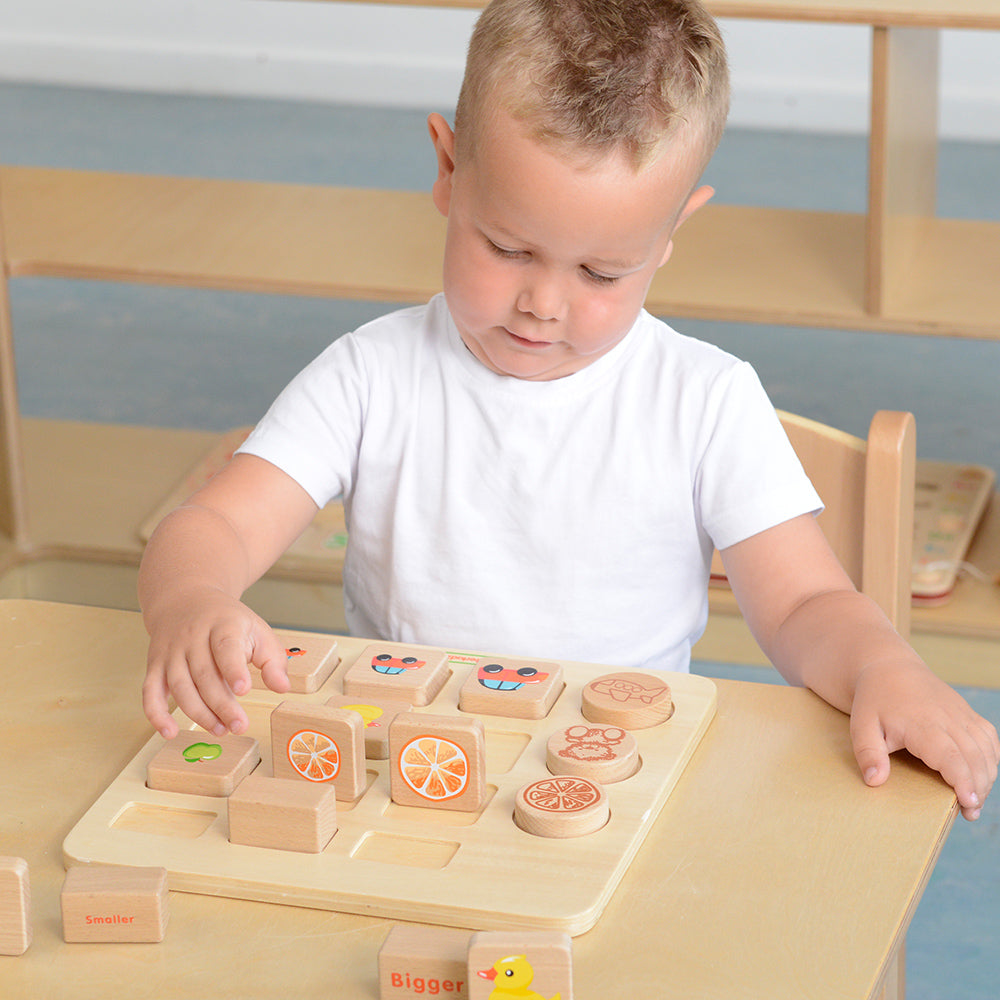Child matching various object cards with corresponding size blocks during educational play