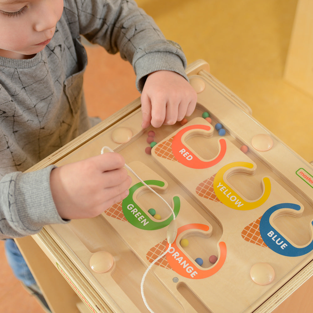 Montessori classroom scene with kids practising colour recognition and grouping.