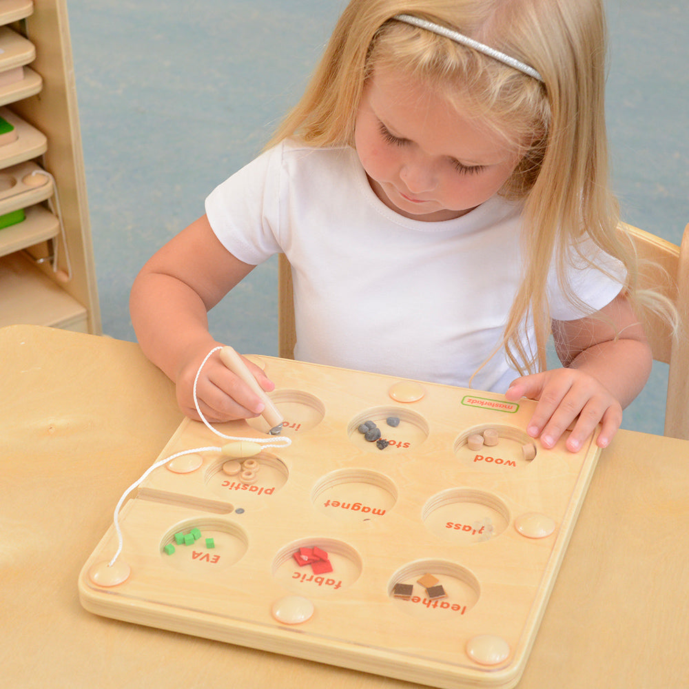 Montessori classroom scene with kids exploring magnetism through hands-on play.