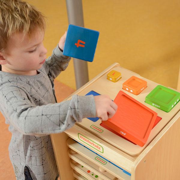 Montessori classroom scene with kids exploring numbers, colours, and sizes.