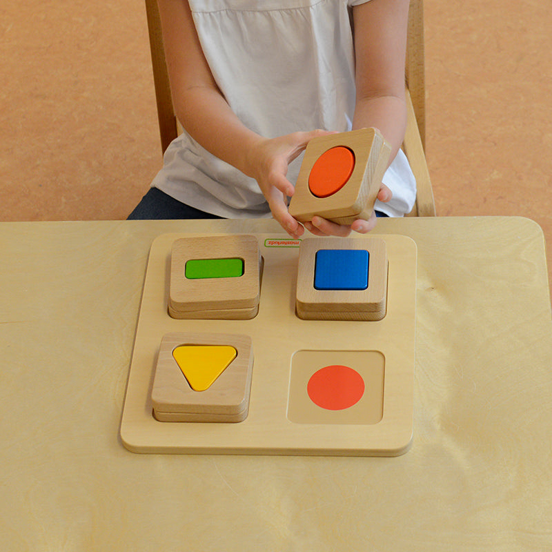 Children stacking and matching blocks by shape, colour, and image on a play table.