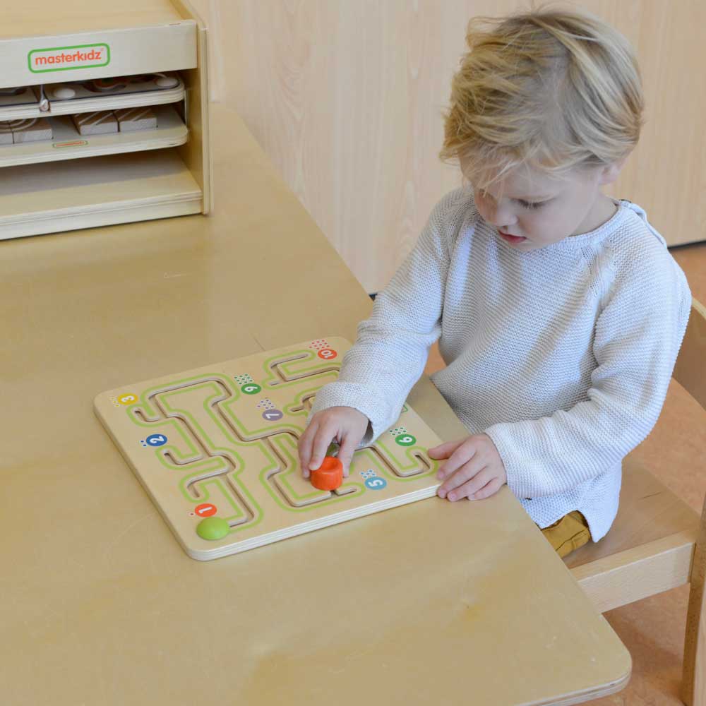 Hands guiding the peg through a logical path between number stations.