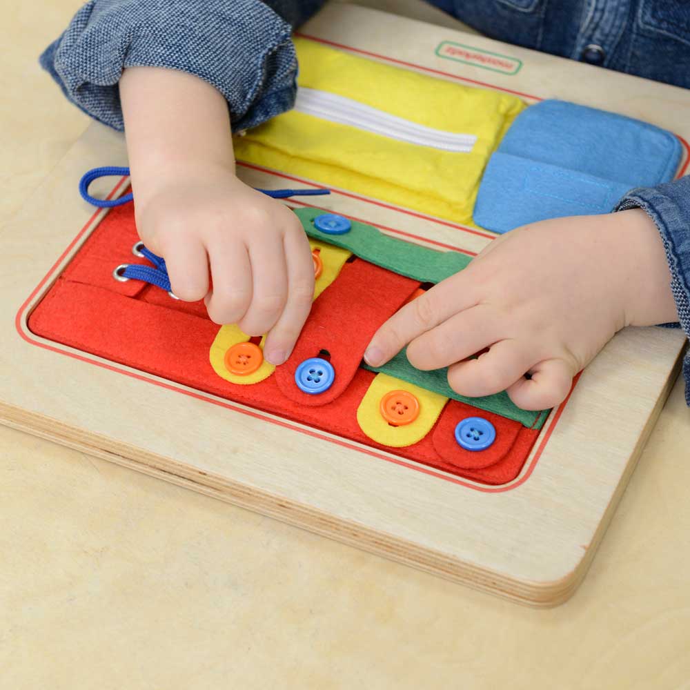 Teacher guiding children through lacing and buttoning exercises.