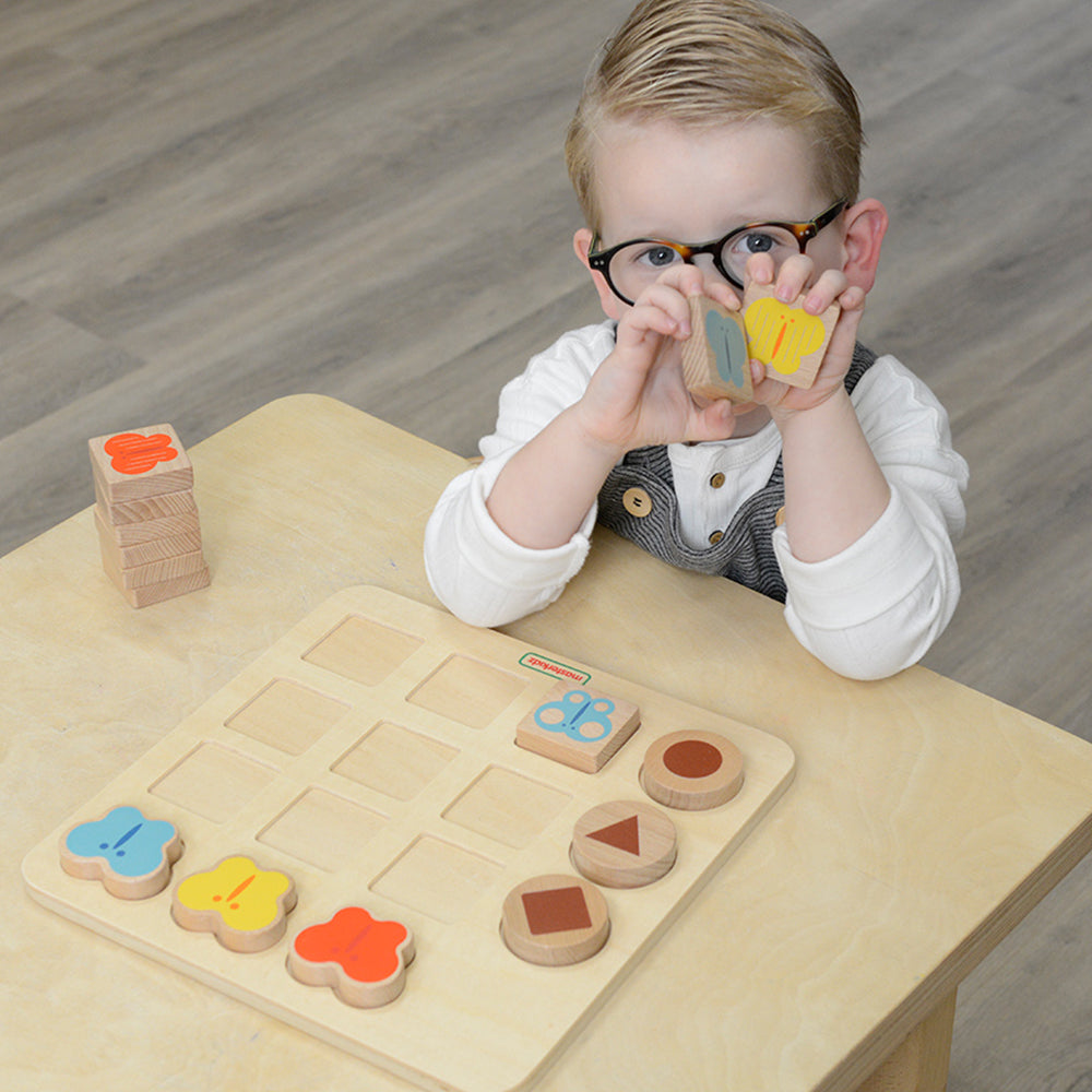 Children sorting butterfly tiles by primary colours and unique patterns.