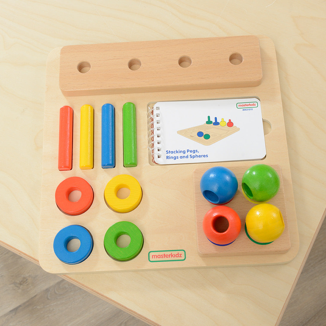 Rings and spheres being sorted by colour on a classroom table.