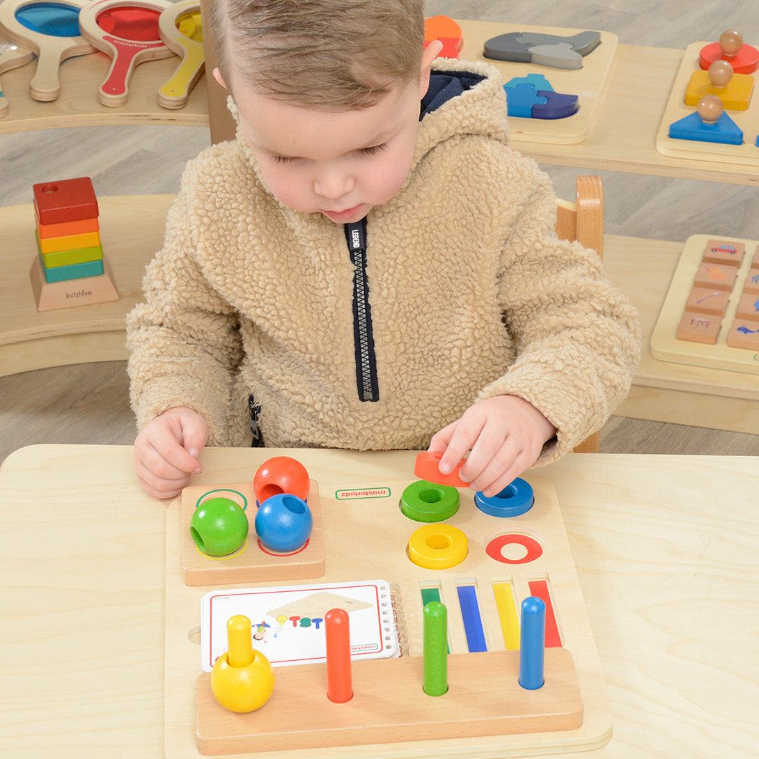 Child stacking a peg with rings and spheres in different combinations.