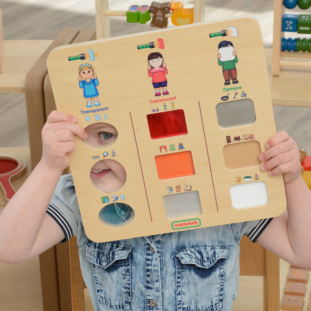 Preschool child using the Masterkidz "Does Light Go Through?" Discovery Board to explore light behaviour.