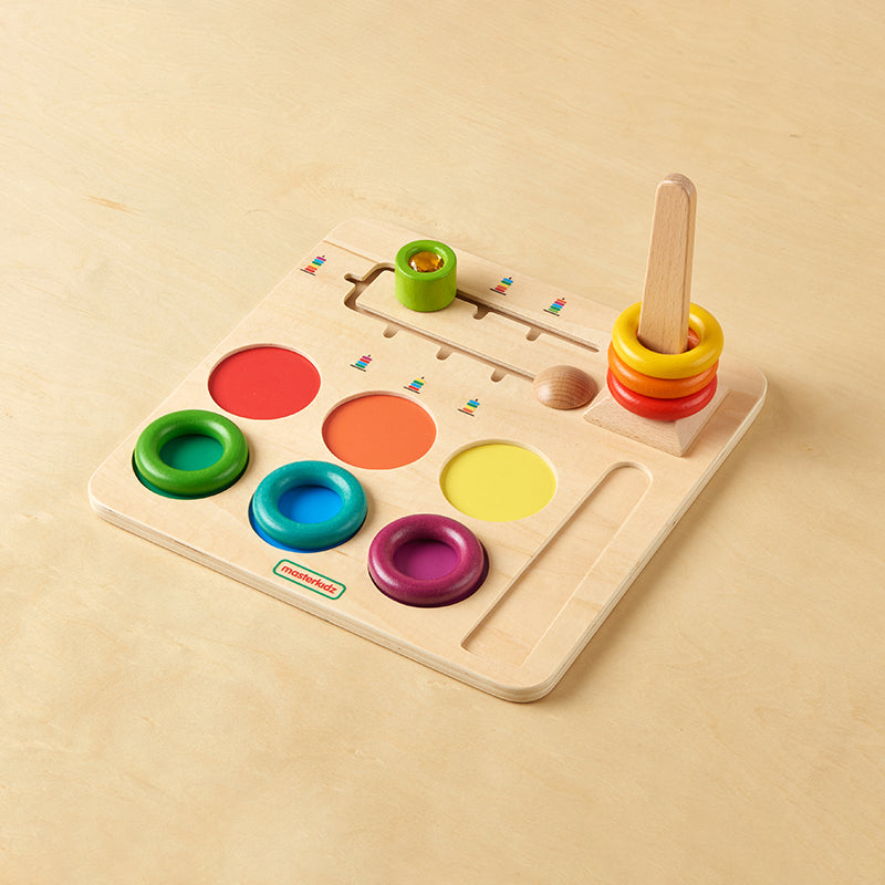 Children concentrating on stacking rings in the correct order on the Masterkidz challenge board.