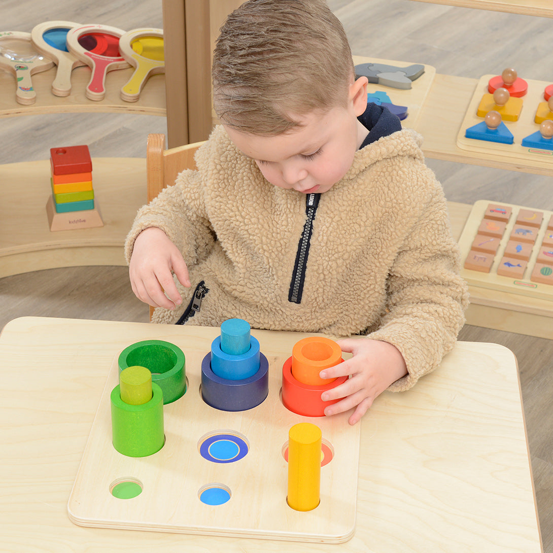 Children stacking the beech wood rods, small tubes and large tubes into tall colourful towers.